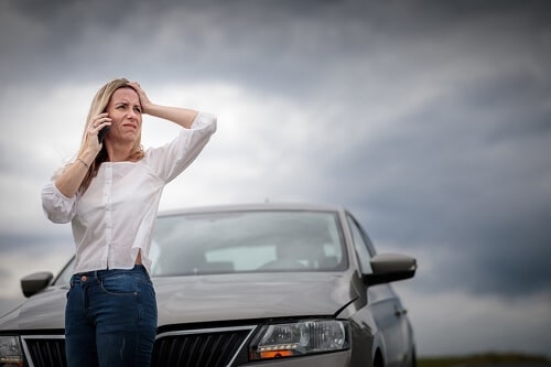 Woman talking on the phone in front of her car; How can I make my car last longer?