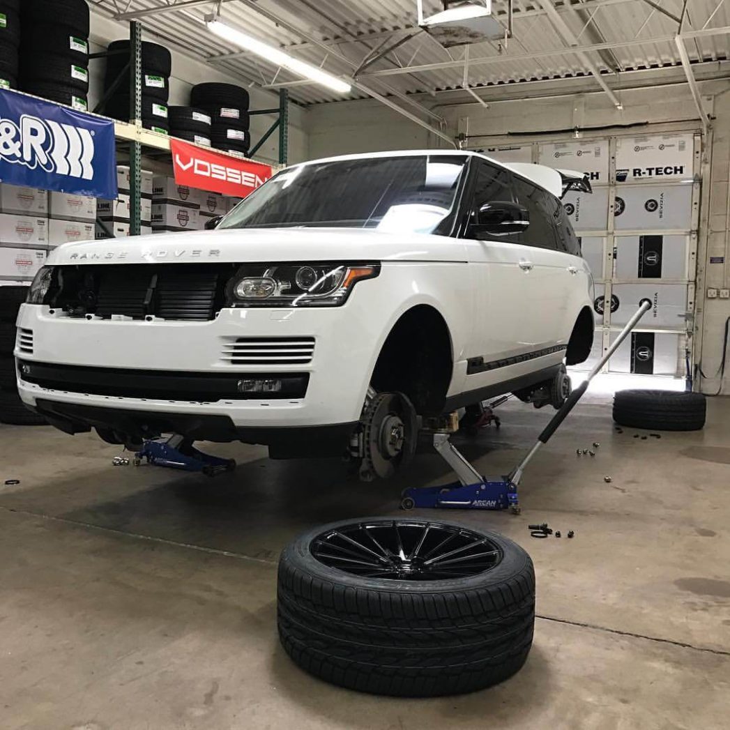 A white range rover raised up without tires. Land Rover repair in Queens Creek, AZ at APA Auto & Fleet Care
