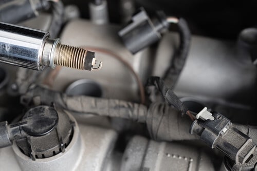Why You Need to Change the Wires When Replacing Spark Plugs at Ace Performance Automotive in Queen Creek Az. ; closeup image of spark plug and wire unhinged