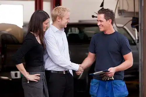 Four Signs You Found The Right Auto Repair Shop | APA Total Care in Queen Creek, AZ. Image of a happy couple shaking hands with an auto mechanic. The couple is happy with the mechanic’s service.
